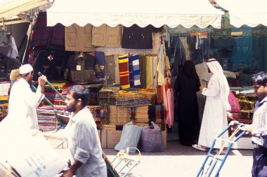 BAE, Dubai - 1 Ekim 2004: Souq ve Market in Old Town ve Dubai 'deki Bur Dubai alışveriş caddelerindeki insanlar.  