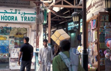 BAE, Dubai - 1 Ekim 2004: Souq ve Market in Old Town ve Dubai 'deki Bur Dubai alışveriş caddelerindeki insanlar.  