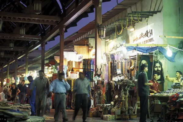 BAE, Dubai - 1 Ekim 2004: Souq ve Market in Old Town ve Dubai 'deki Bur Dubai alışveriş caddelerindeki insanlar.  