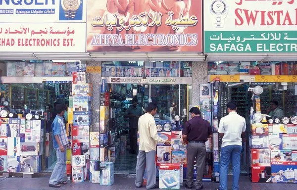 BAE, Dubai - 1 Ekim 2004: Souq ve Market in Old Town ve Dubai 'deki Bur Dubai alışveriş caddelerindeki insanlar.  