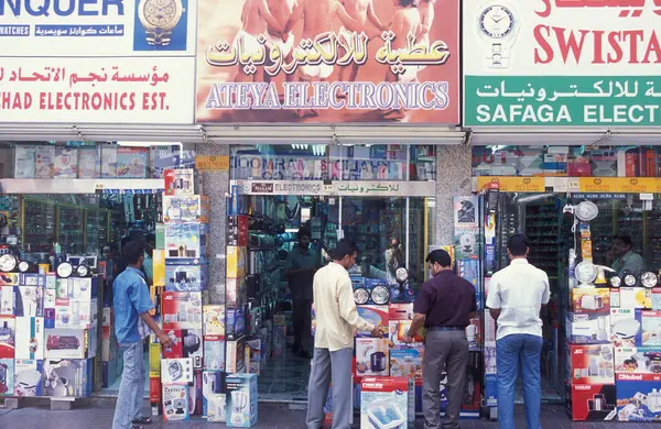 BAE, Dubai - 1 Ekim 2004: Souq ve Market in Old Town ve Dubai 'deki Bur Dubai alışveriş caddelerindeki insanlar.  