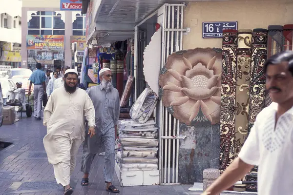 BAE, Dubai - 1 Ekim 2004: Souq ve Market in Old Town ve Dubai 'deki Bur Dubai alışveriş caddelerindeki insanlar.  