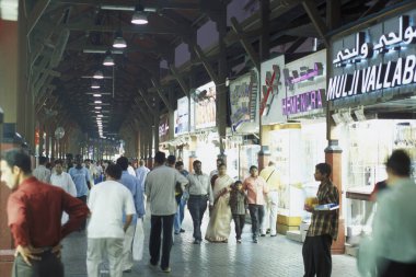 BAE, Dubai - 1 Ekim 2004: Souq ve Market in Old Town ve Dubai 'deki Bur Dubai alışveriş caddelerindeki insanlar.  