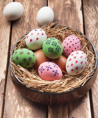Tahta arka planda yuvada paskalya yumurtaları