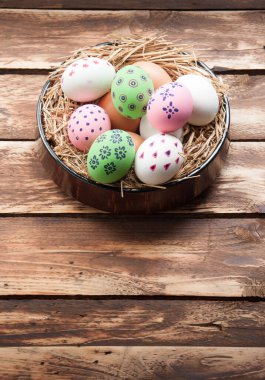 Tahta arka planda yuvada paskalya yumurtaları