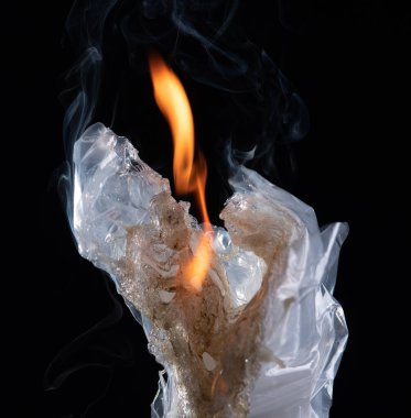 The fire is burning plastic bag on a dark background.