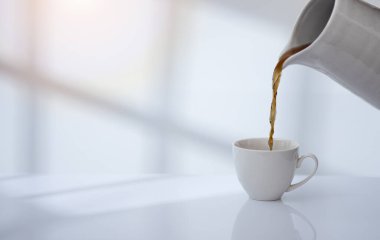 Coffee cup on table with window light and shadow drop on white wall background