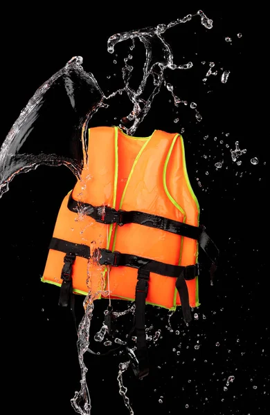 Orange life jacket with water splash on black background