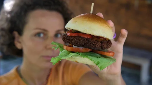 Молодая Женщина Ресторане Показывает Вегетарианский Вкусный Гамбургер Заменителем Мяса Концепция Лицензионные Стоковые Изображения