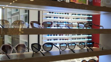 Optics shop. The windscreen offers a wide selection of sunglasses. From glasses with brown, gray and green lenses to red in a fashionable, light frame and different materials.