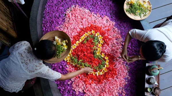温泉酒店的员工准备一个浴池 用各种颜色的花瓣填满 在浴池里放上鲜花 你可以从路上放松下来 恢复体力和健康 Ubud 印度尼西亚 2022年 图库图片
