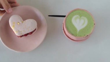 Festive breakfast for valentines day heart shaped delicious cake and mug with heart shaped foam matches. A romantic breakfast for the holiday of all lovers in a confectionery cafe.