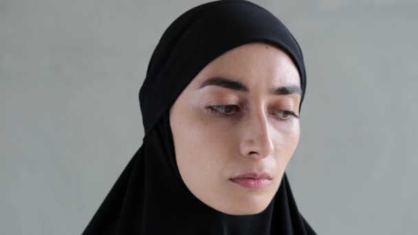 黒いヒジャーブの悲しい女性は 痛みと絶望に満ちて検索し カメラに熱心に見つめます 女性の権利を制限するイスラム教の宗教の厳格な規則でイスラム世界を巡航 — ストック動画