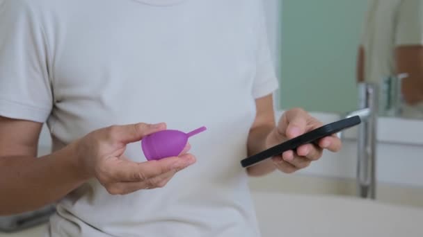 Одна Жінка Ванній Кімнаті Тримає Менструальну Чашку Рожевого Силікону Шукає — стокове відео
