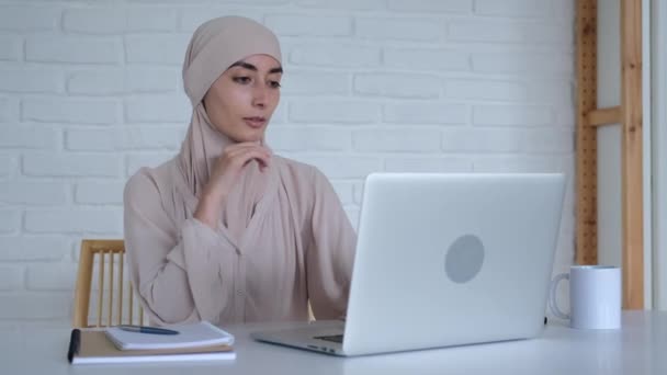 Een Mooie Moslimvrouw Een Hijab Zit Aan Een Tafel Gebruikt — Stockvideo