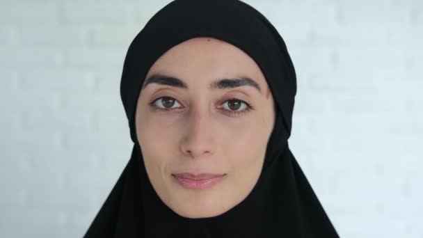 Zbliżenie Twarzy Muzułmanki Czarnym Hidżabie Białej Ścianie Uśmiechniętej Patrzącej Kadr — Wideo stockowe