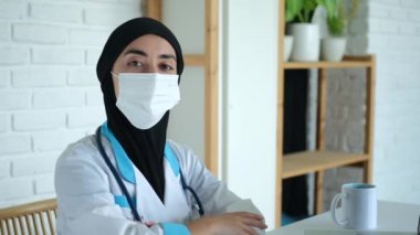 Bir sağlık çalışanı hastalarını kabul ettiği ofiste onayını veriyor. Müslüman bir kadın doktor olarak çalışır. Tıp fakültesinde okuyan bir öğrenci hastanede staj yapıyor. Maskeli doktor..
