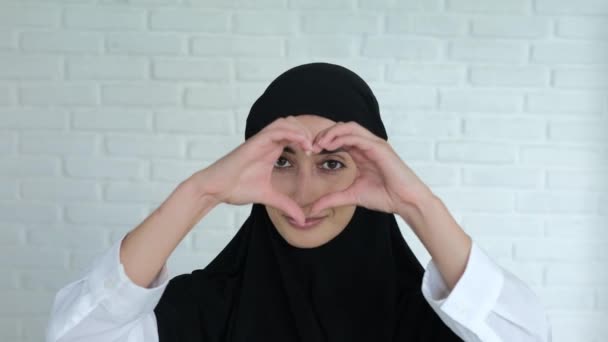Een Moslimvrouw Een Zwarte Hijab Glimlacht Lief Toont Een Teken — Stockvideo