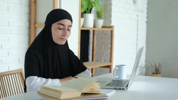 ヒジャーブの女子学生が遠隔教育を受けている イスラム教徒の女性は 利用可能なすべての技術を使用してコンピュータで勉強します 教育を受けるムスリム女性の権利 — ストック動画