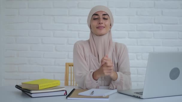 Een Jonge Moslimvrouw Een Hijab Zit Aan Een Tafel Glimlacht — Stockvideo