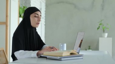 An Arab student studying at an international university uses a laptop remotely via the Internet. Online education abroad for all categories of citizens, regardless of gender and religion.