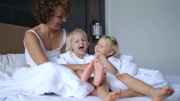 Στιγμιαία Πλάνα Γελαστά Παιδιά Κείτονται Ένα Μεγάλο Κρεβάτι Μητέρα Τους — Αρχείο Βίντεο