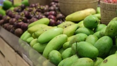 Fruits in the market on the shelves fresh mango and mangosteen. The Asian local market sells the freshest and healthiest fruits that will fill you with vitamins and energy. Selling fruit in a shop.