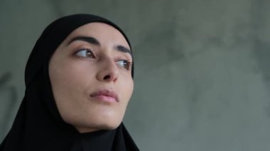 Adil cinsiyetin bir temsilcisinin yakın çekimi, Müslüman bir kadın kameraya bakıyor. Mütevazı ve sık sık görünüyor. İslam 'da kadınlar için zalim kurallar, başörtüsü takmak zorunludur..