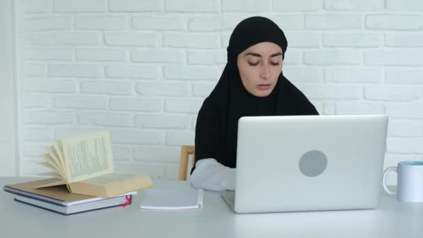Een Jonge Moslimstudent Leest Informatie Van Een Laptop Schrijft Een — Stockvideo
