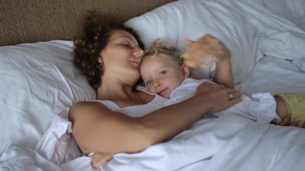 Una Giovane Madre Con Una Bambina Appena Svegliata Sono Sdraiata — Video Stock