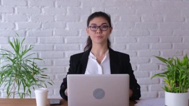 Young asian woman working using laptop on desk in living room at home. Asia business woman success celebration feeling happy. Woman with glasses at work in the office showing thumbs up.