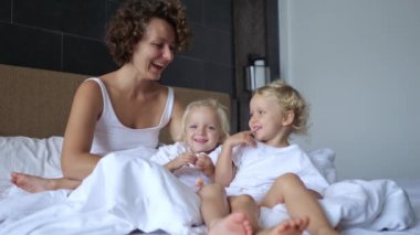 Happy children spend morning hours after waking up with a parent. They have fun, communicate, are charged with positive energy from joint communication.