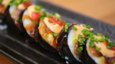 Close-up of Japanese rolls in the best authentic restaurant. Rolls with fish and seafood cut into small pieces convenient for eating. Japanese rolls wrapped in nori with rice and stuffing inside
