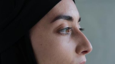 Close-up of a modest Arab woman. This woman does not use makeup. A woman has natural beauty. Muslim rules for women who profess Islam and wear a black hijab. Islamic world in the Middle East.