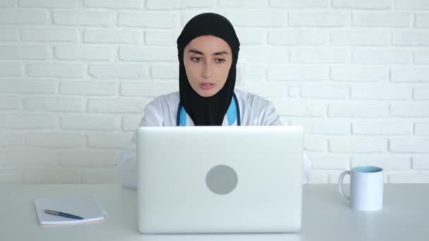 Konsultacja Internetowa Pacjenta Muzułmańskiej Klinice Lekarz Hidżabie Mundur Medyczny Siedzi — Wideo stockowe
