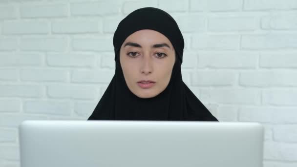 黒人ヒジャーブの女性がビジネスパートナーと話している イスラム教徒のビジネス女性は コンピュータのオフィスで働いています ムスリム女性のためのリモートフリーランスの仕事 — ストック動画