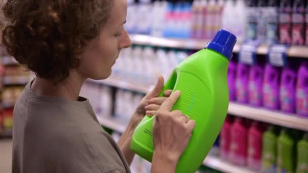 Woman Carefully Checks Composition Fabric Softener Green Plastic Bottle European — Vídeo de stock