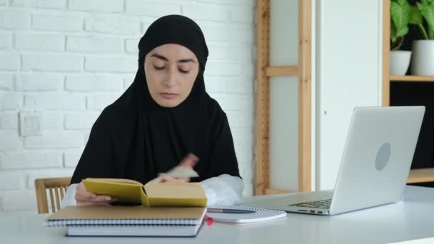 Beautiful Muslim Woman Black Hijab Sits Table Reading Book Making — Vídeos de Stock