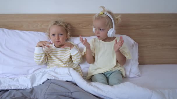 Dwie Dziewczyny Leżą Łóżku Piżamie Słuchając Muzyki Tańcząc Rytmie Melodii — Wideo stockowe