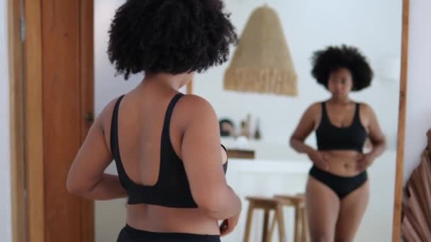 一位穿着黑色女士内衣的美丽的非洲裔美国女人在镜子前看着她性感的卷曲型 身体积极的概念 多种族妇女在镜子前 — 图库视频影像