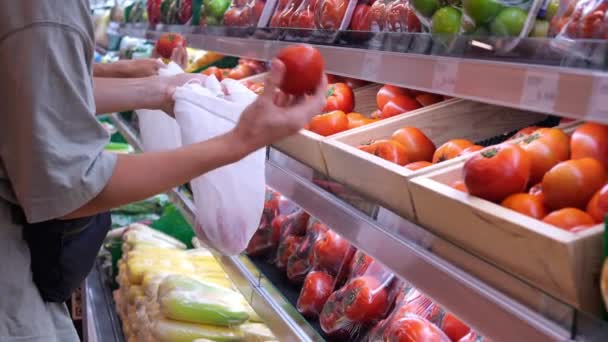 Μια Γυναίκα Παίρνει Κόκκινες Ντομάτες Από Ένα Ράφι Και Βάζει — Αρχείο Βίντεο