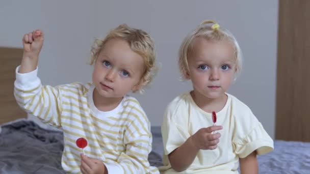 Two Sisters Sit Facing Camera Both Babies Sitting Bed Each — Stock video