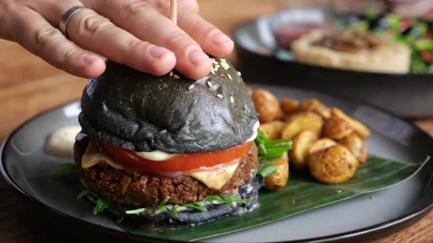 Ludzka Ręka Wyciska Serdecznego Czarnego Burgera Szpikulcem Środku Hamburger Czarną — Wideo stockowe