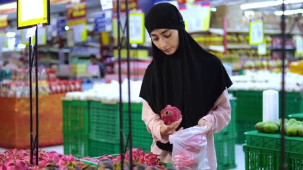 Mujer Musulmana Joven Gran Supermercado Mostrador Selecciona Pone Una Fruta — Vídeos de Stock