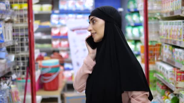 Νεαρή Μουσουλμάνα Μαντίλα Στη Μέση Του Μαγαζιού Απαντά Εισερχόμενη Κλήση — Αρχείο Βίντεο