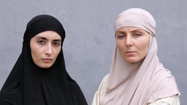 Portret Dwóch Marszczących Brwi Islamskich Kobiet Hidżabami Patrzących Poważnie Kamerę — Wideo stockowe