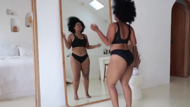 下着姿で鏡の前で魅力的なプラスサイズの黒人女性が踊り 自分の身体の美しさと人生を楽しむ 愛と脂肪と太りすぎの受け入れ 体の形の多様性 — ストック動画