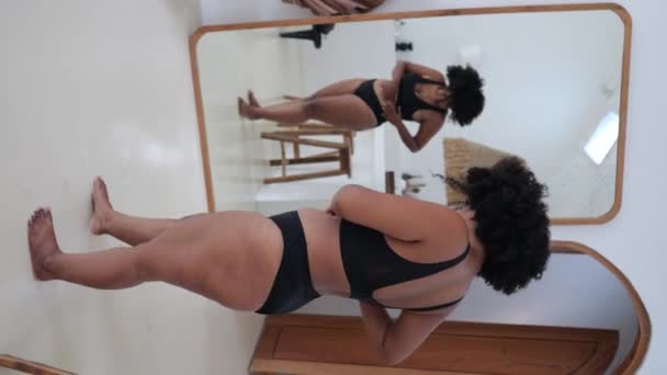 太りすぎの下着を着た魅力的な多民族プラスサイズの女性は 鏡の前に立って彼女の体を賞賛しながら 彼女のセクシュアリティを学びます あなた自身の体 体の正の受け入れ 自分自身を愛し — ストック動画