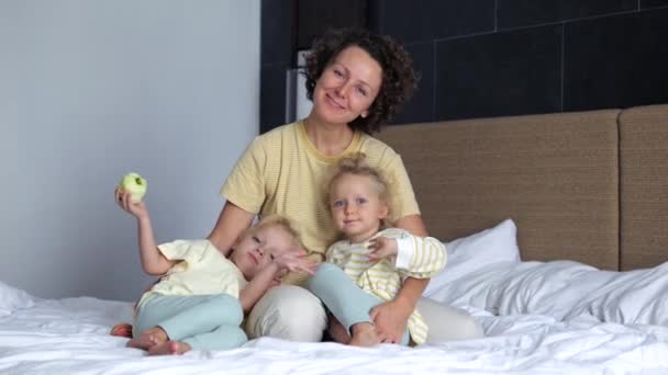 Mamá Dos Hijas Sentadas Cama Sonriendo Mirando Cámara Las Niñas — Vídeos de Stock