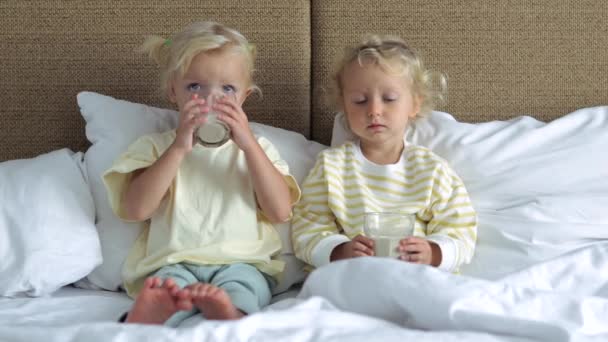 Två Flickor Sitter Sängen Och Dricker Varm Mjölk För Att — Stockvideo